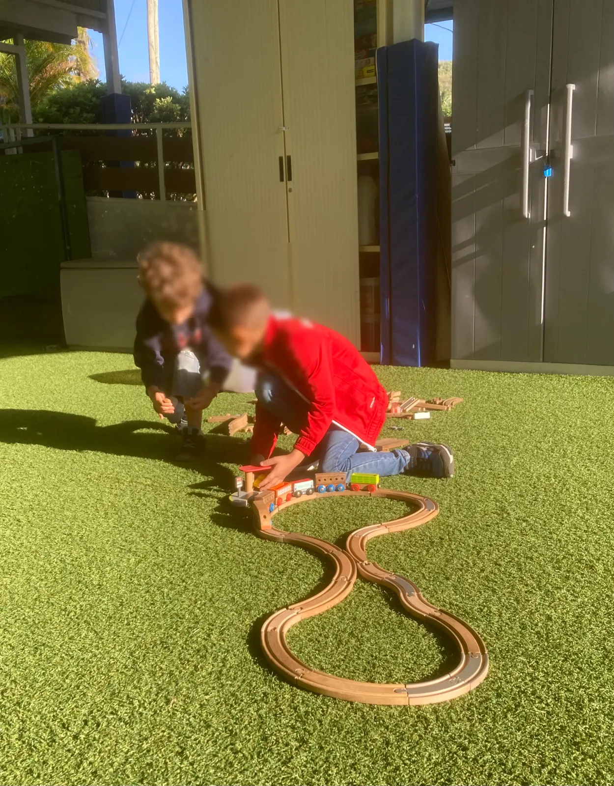 Enfants jouant avec un petit train en milieu scolaire