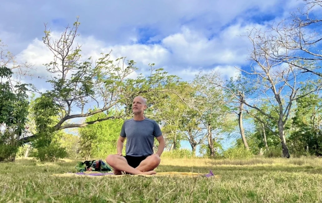 Éric Boisteau assis dans l’herbe en plein air