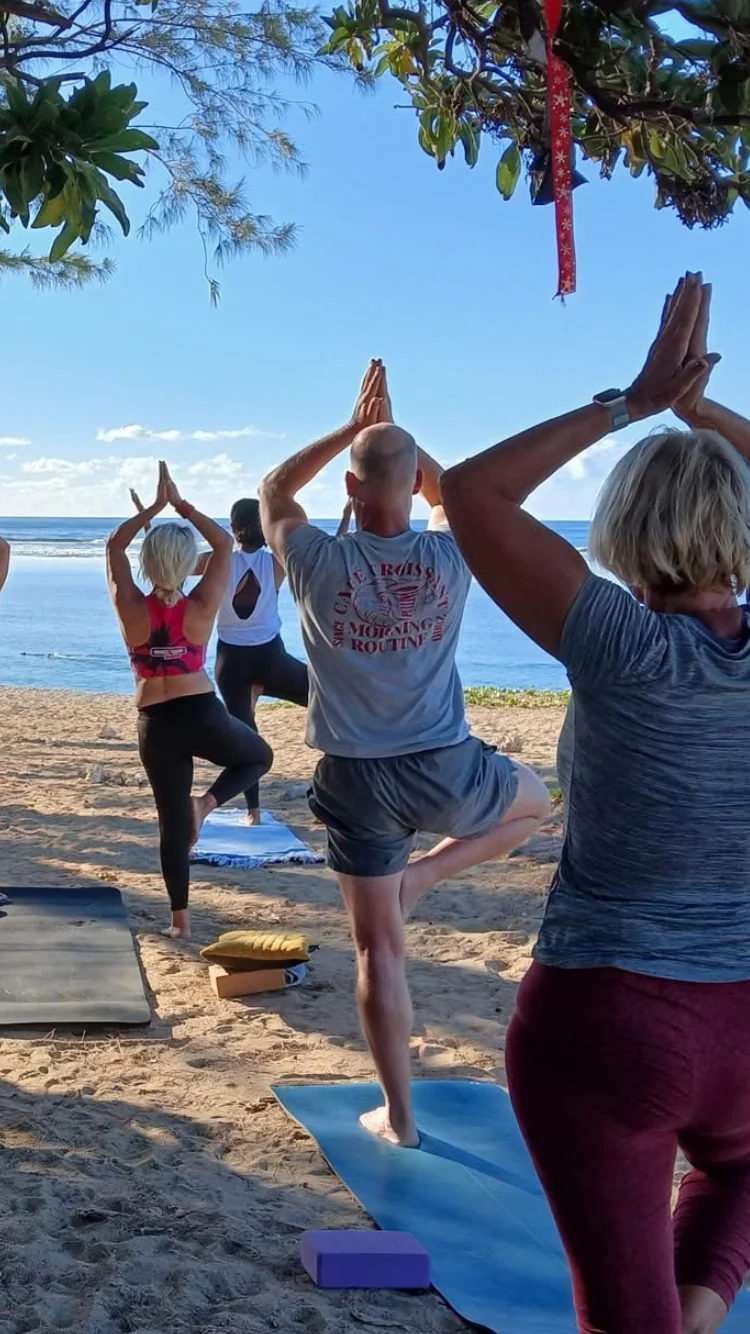 Groupe pratiquant en plein air sur une plage, photographié de dos