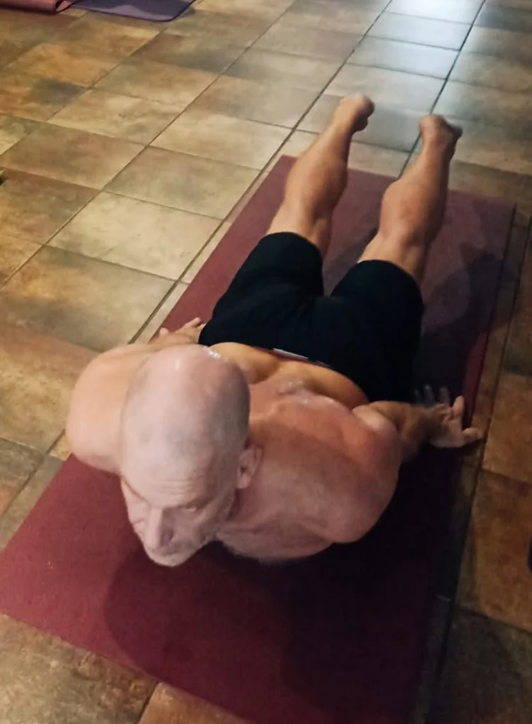 Pratiquant effectuant un exercice au sol en intérieur